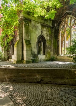 Carved stone windows of St Dunstan church in City of London covered with foliage