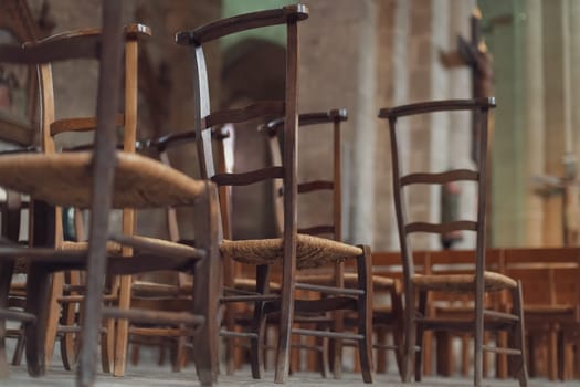 Row of wooden chairs inside in a church in France.