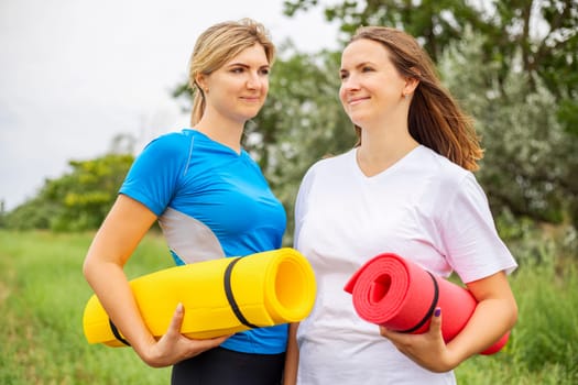 Two woman girlfriends outdoor yoga retreat. Healthy lifestyle and sport concept .