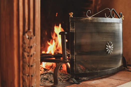 Fire in a french old fireplace with a fire shield