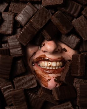 The face of a caucasian woman surrounded by sweets. The girl is smeared in sweets