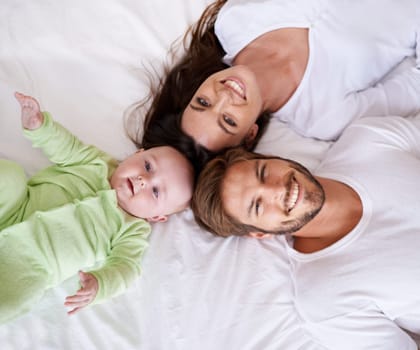 Top view portrait of mother, father and baby on bed for love, care and quality time together at home. Happy parents, family and cute newborn kid relax in bedroom with smile, support and fun bonding.