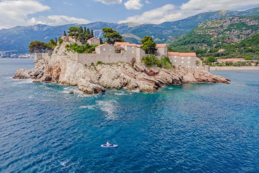 Young women Having Fun Stand Up Paddling in blue water sea near st stefan island in Montenegro. SUP.