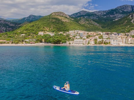 Young women Having Fun Stand Up Paddling in blue water sea near st stefan island in Montenegro. SUP.