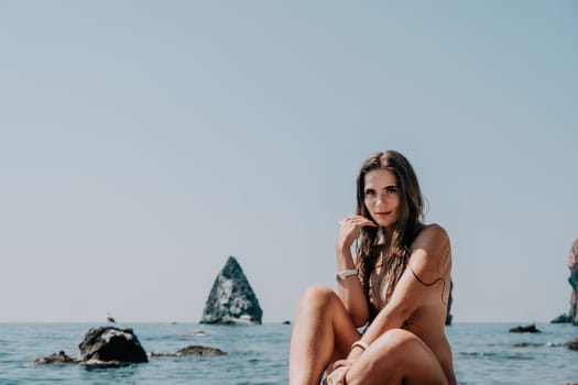 Woman summer sea. Happy woman swimming with inflatable donut on the beach in summer sunny day, surrounded by volcanic mountains. Summer vacation concept