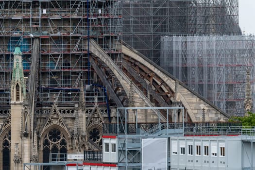 6 May 2023. Paris, France. Flying buttresses of Notre Dame cathedral are visible emerging from scaffolding. Gothic details, tracery are visible.