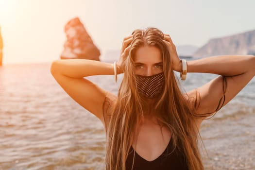 Woman travel sea. Young Happy woman in a long red dress posing on a beach near the sea on background of volcanic rocks, like in Iceland, sharing travel adventure journey