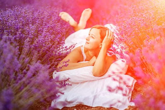 Woman lavender field. A middle-aged woman lies in a lavender field and enjoys aromatherapy. Aromatherapy concept, lavender oil, photo session in lavender.