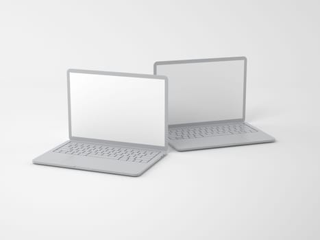 Two open modern gray laptops with blank screens on a light background