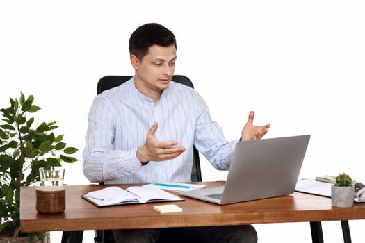 young friendly Freelancer man talking on video call to client, sitting on chair at desk, using laptop