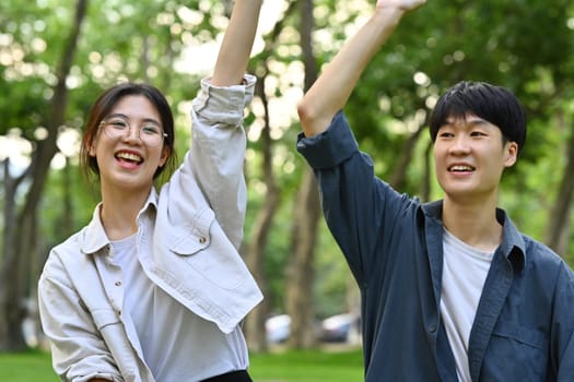 Happy female and male classmates having fun celebrating and laughing. Friendship, community, youth and university concept.