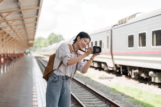 Traveler girl taking photo in train station.