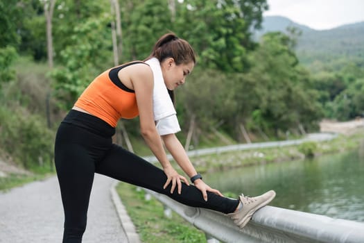Young woman exercising at park. Beautiful athletic woman doing her stretches in the park. Sporty woman stretching after a good workout session outdoor.