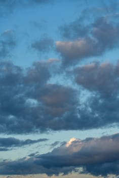 Stunning blue summer sky with fluffy cumulus clouds at sunset, creating a breathtaking background for text or designs.