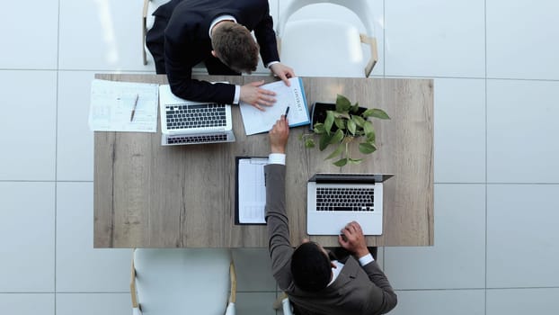 two businessmen sitting on a chair and watching something on a laptop