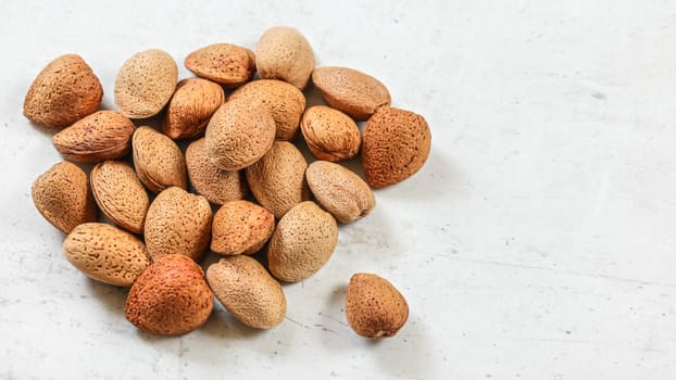 Whole almonds in shell, on white board.