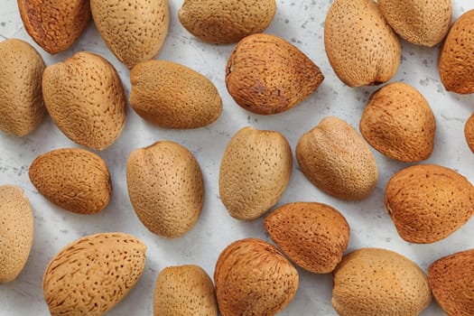 Top down view, whole almonds in shell on white board.