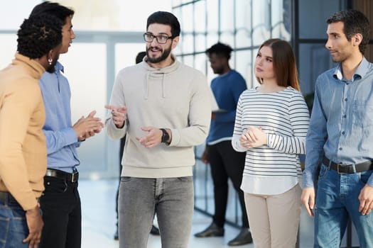 Laughing multiethnic business people talking in the office.