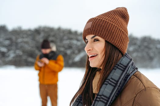 Woman in winter warm jacket walking in snowy winter forest, close up