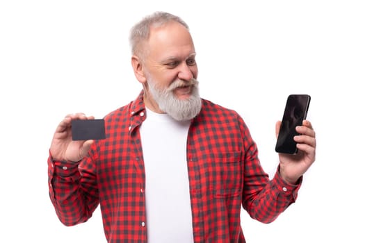 handsome 60s retired man with white beard and mustache showing bank card.