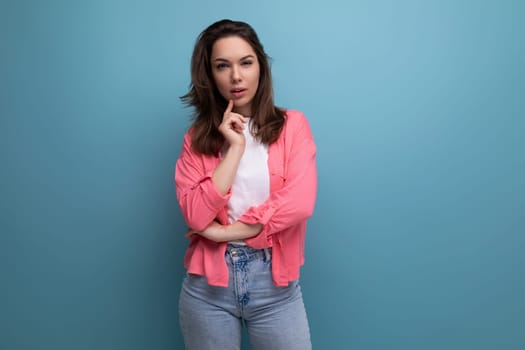 calm brunette young woman with shoulder-length hair in a pink shirt and jeans.