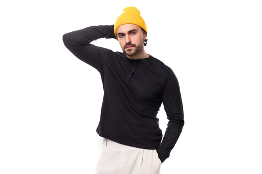 young well-groomed stylish brunette European brutal man in a black sweatshirt on a white background with copy space.