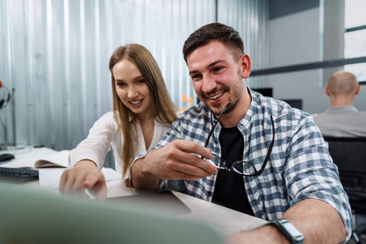 Two entrepreneurs man and woman sitting together working in an office, close up