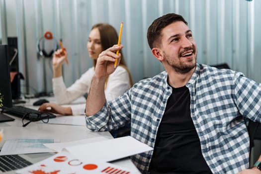 Two entrepreneurs man and woman sitting together working in an office, close up