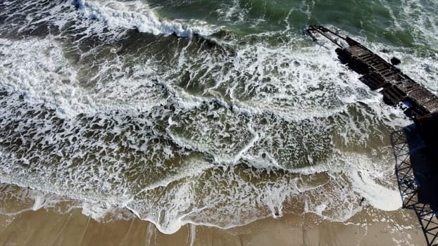 Aerial Drone View Flight Over Old Breakwater on Sandy Beach. Top View Waves with White Foam Sandy Shore. Landscape Tropical Beach and Coastline. Concept Eco, Environment, Climate Change, Traveling