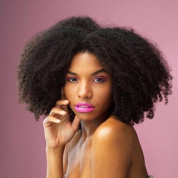 Face, hair care and serious black woman with makeup in studio isolated on a pink background for skincare. Hairstyle portrait, cosmetics and African female model with salon treatment for afro beauty