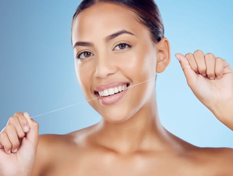 Floss, teeth and portrait of woman in studio for beauty, healthy body and hygiene on blue background. Female model, tooth flossing and cleaning mouth for facial smile, fresh breath and happy dental.