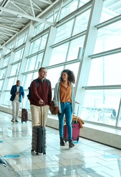 Travel, happy and smile with interracial couple in airport for vacation, tourism and departure. International trip, luggage and holiday with man and black woman walking for flight, journey or airline.