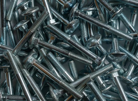 Background of metal screws randomly scattered. Selective focus