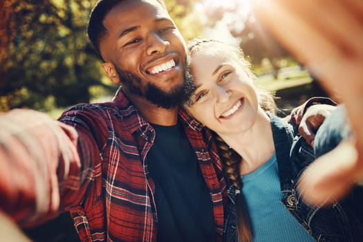 Diversity couple, love selfie and portrait outdoors, having fun and bonding together in nature. Comic smile, interracial romance and black man and woman take pictures for happy memory or social media.