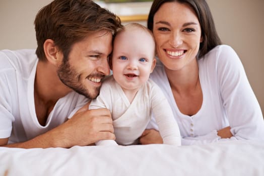 Portrait, happy family and parents with baby on bed for love, care and quality time together at home. Mother, father and newborn child relaxing in bedroom for development, caring support or happiness.
