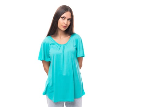 young pretty european woman with dark long hair dressed in blue casual clothes on a white background.