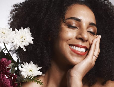 Makeup, flowers and happy black woman with skincare satisfaction and glowing texture routine. Aesthetic, health and wellness of confident cosmetics model with beautiful smile in white studio