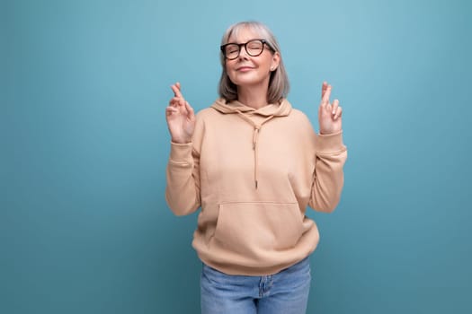 fashionable grandmother in a youth outfit on a studio background with copy space.