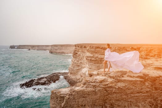 Woman sea white dress. Happy freedom woman on the beach enjoying and posing in white dress. Rear view of a girl in a fluttering white dress in the wind. Holidays, holidays at sea