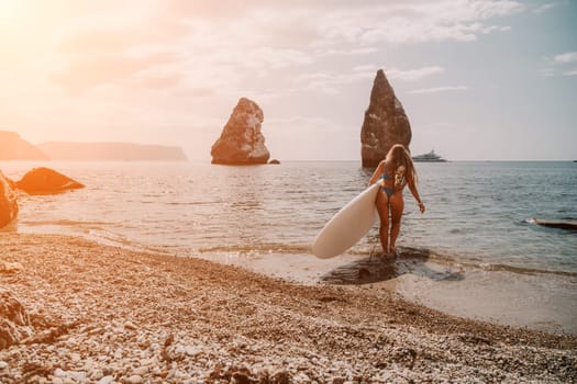 Close up shot of beautiful young caucasian woman with black hair and freckles looking at camera and smiling. Cute woman portrait in a pink bikini posing on a volcanic rock high above the sea