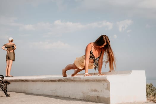 Woman park yoga. Side view of free calm bliss satisfied woman with long hair standing in morning park with yoga position against of sky by the sea. Healthy lifestyle outdoors in park, fitness concept