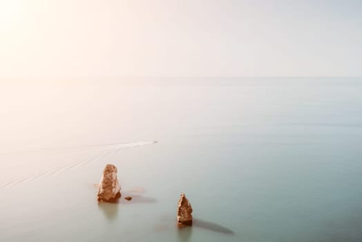 Aerial panoramic view of beautiful sunset above sea. Beautiful seascape. Sun glare, small waves on the water surface. Evening. Horizon. Nobody. No people. Copy space. Never-ending beauty of nature