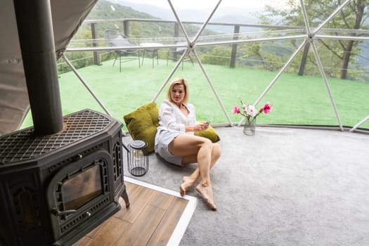 woman with smartphone in geo dome tent.