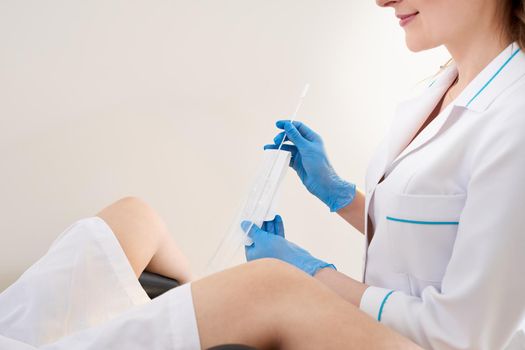 Gynecologist using vaginal swab for STD testing. Woman in gynecological chair