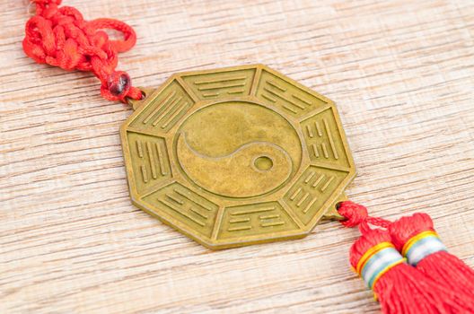 Close up metal sign of Yin Yang coin on wooden background