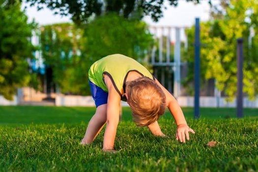 The child spends time in the park, he is very happy. Have fun and enjoy a summer day. Walking and recreation. Portrait of a happy child