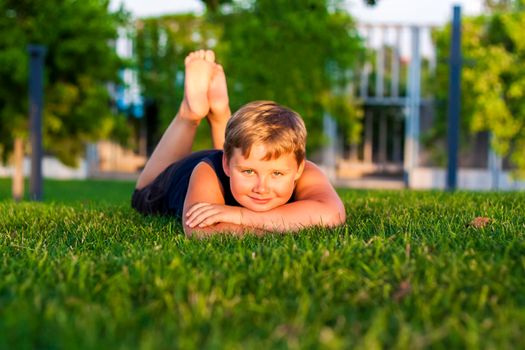 The child spends time in the park, he is very happy. Have fun and enjoy a summer day. Walking and recreation. Portrait of a happy child