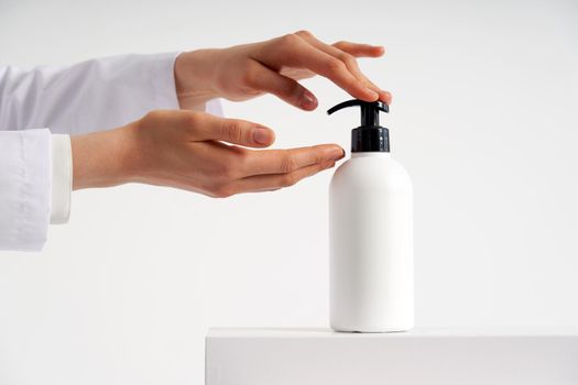 Woman hands pushing pump plastic soap bottle