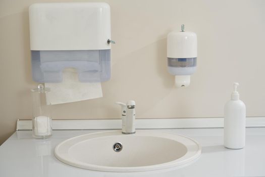 Faucet and liquid soap bottle on a sink background. High quality photo