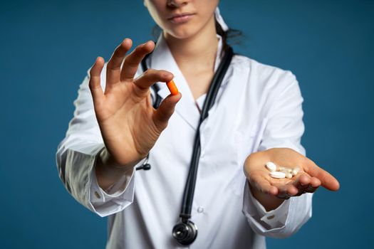 female pharmacist holding a pill, health care and prevention concept, hand close up
